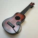 Music-orientated children's guitar toy that can be played with a pick to imitate basic musical instruments, resembling a ukulele - Image 7